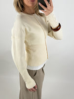 Stemningsbillede af pige der bærer en creme farvet RORY cardigan. Fra BySofieSønderby