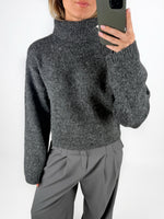 Modelfoto af pige i grå ROSANNA striktrøje med rullekrave, samt grå LISA bukser. Alt er fra BySofieSønderby.