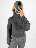 Modelfoto af pige i grå ROSANNA striktrøje med rullekrave, samt grå LISA bukser. Alt er fra BySofieSønderby.