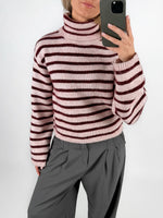 Modelfoto af pige i lyserødstribet ROSANNA striktrøje med rullekrave, samt grå LISA bukser. Alt er fra BySofieSønderby.