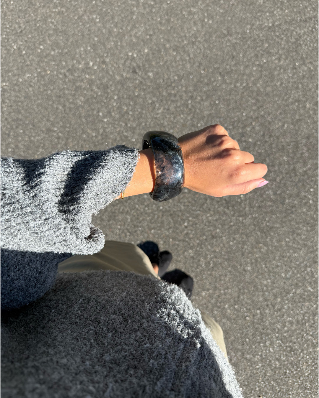 Modelfoto af en Saige armbånd i grå. Baggrund er grå. Fra BySofieSønderby