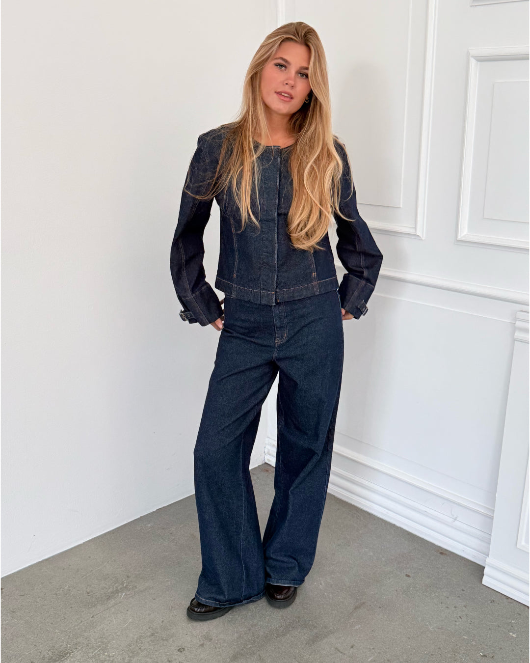 Modelfoto af pige i mørkeblå SAVA jeans, samt mørkeblå FLO jakke. Alt er fra BySofieSønderby.