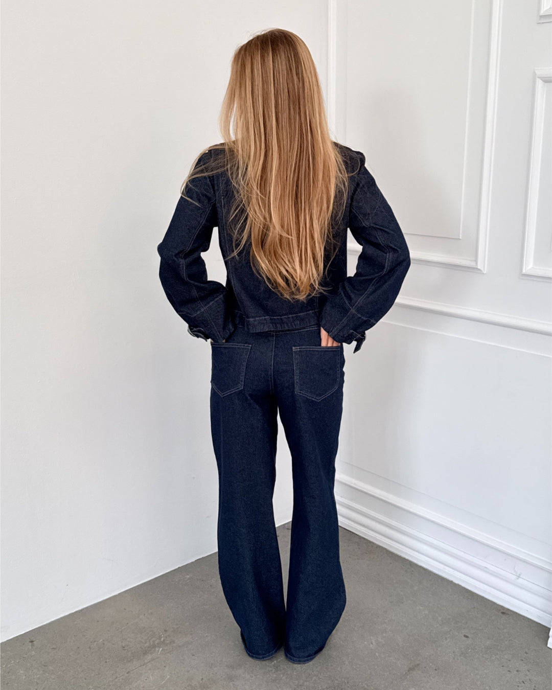 Modelfoto af pige i mørkeblå SAVA jeans, samt mørkeblå FLO jakke. Alt er fra BySofieSønderby.