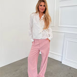 Modelfoto af pige i lyserøde SELENA bukser, samt hvid HOPE top. Alt er fra BySofieSønderby.