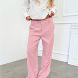 Modelfoto af pige i lyserøde SELENA bukser, samt hvid HOPE top. Alt er fra BySofieSønderby.