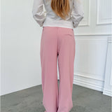 Modelfoto af pige i lyserøde SELENA bukser, samt hvid HOPE top. Alt er fra BySofieSønderby.