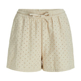 Shorts i blød beige stof, dekoreret med små broderede blomsterhuller, har en elastisk talje og bindebånd, synlig på en hvid baggrund.