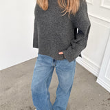 Modelfoto af pige i grå SIGGA strik, samt blå NANNA jeans. Alt er fra BySofieSønderby.