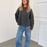 Modelfoto af pige i grå SIGGA strik, samt blå NANNA jeans. Alt er fra BySofieSønderby.