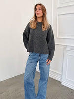 Modelfoto af pige i grå SIGGA strik, samt blå NANNA jeans. Alt er fra BySofieSønderby.