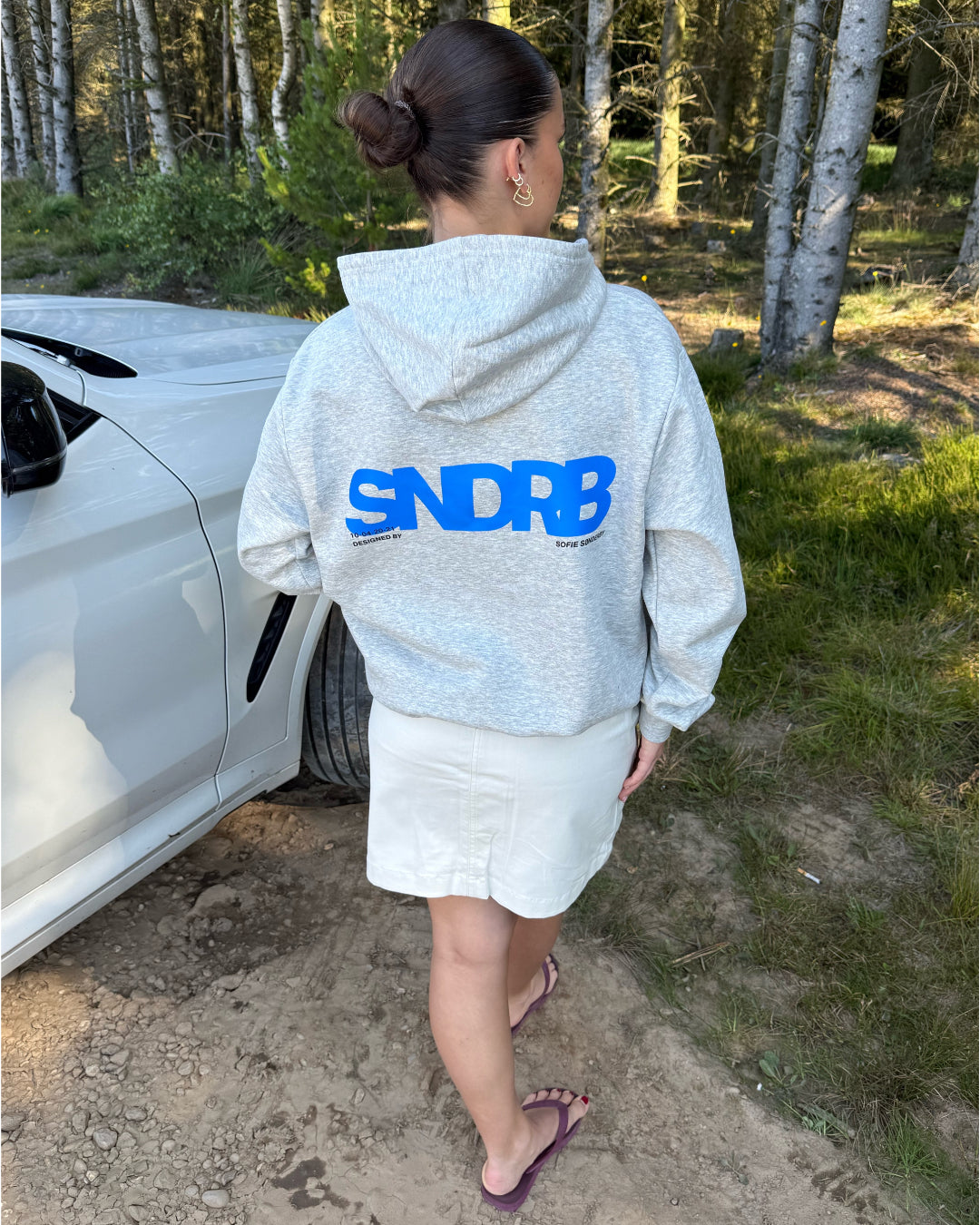 Modelfoto af pige, som bærer SNDRB hoodie, grå og KENDAL nederdel, creme - alt fra BySofieSønderby