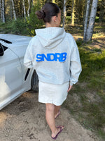 Modelfoto af pige, som bærer SNDRB hoodie, grå og KENDAL nederdel, creme - alt fra BySofieSønderby