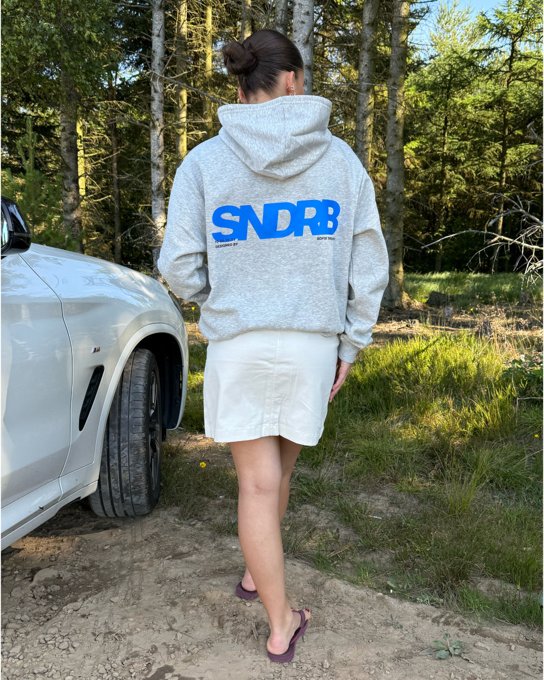 Modelfoto af pige, som bærer SNDRB hoodie, grå og KENDAL nederdel, creme - alt fra BySofieSønderby