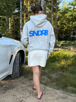 Modelfoto af pige, som bærer SNDRB hoodie, grå og KENDAL nederdel, creme - alt fra BySofieSønderby