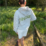 Modelfoto af pige, som bærer SNDRB hoodie, grå og KENDAL nederdel, creme - alt fra BySofieSønderby