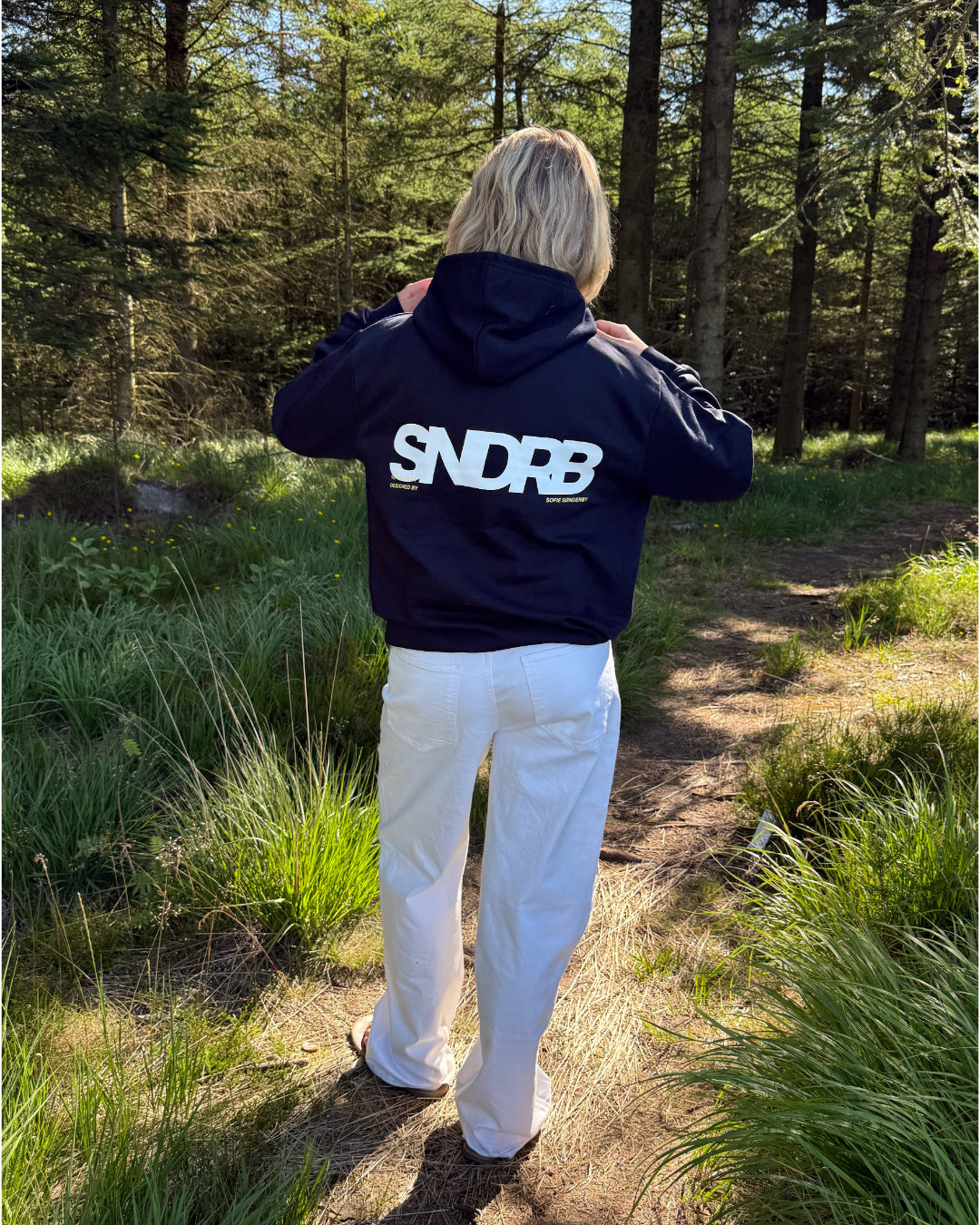 Modelfoto af pige, som bærer SNDRB hoodie, navy og NANNA jeans, hvid - alt fra BySofieSønderby