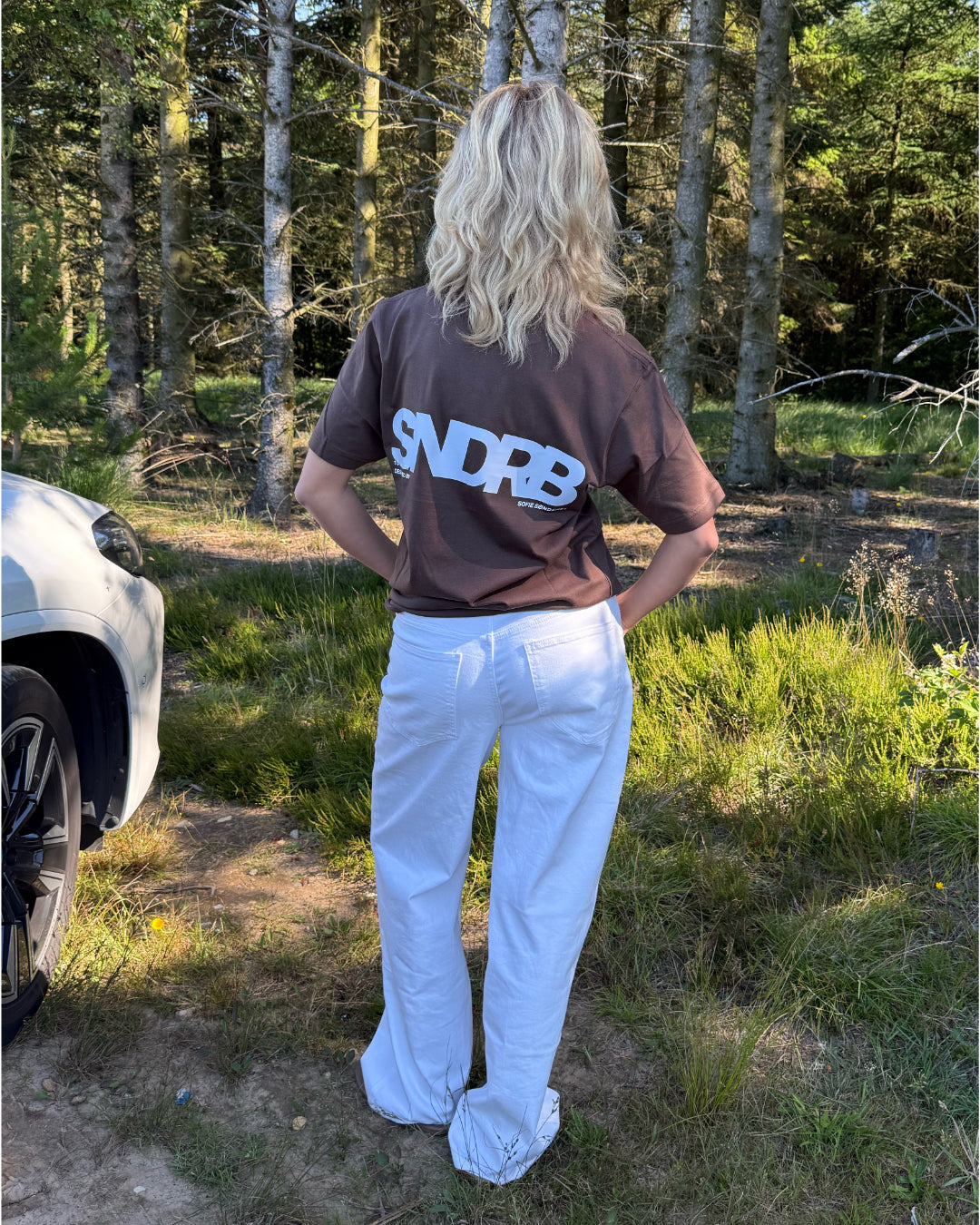 Modelfoto af pige, som bærer SNDRB t-shirt, brun og NANNA jeans, hvid - alt fra BySofieSønderby
