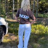 Modelfoto af pige, som bærer SNDRB t-shirt, brun og NANNA jeans, hvid - alt fra BySofieSønderby
