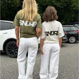 Modelfoto af pige, som bærer SNDRB t-shirt, hvid og hvid nederdel - alt fra BySofieSønderby