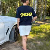 Modelfoto af pige, som bærer SNDRB t-shirt, navy og hvid nederdel - alt fra BySofieSønderby