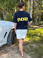 Modelfoto af pige, som bærer SNDRB t-shirt, navy og hvid nederdel - alt fra BySofieSønderby