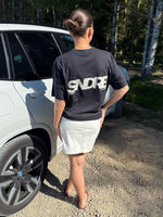 Modelfoto af pige, som bærer SNDRB t-shirt, sort og hvid nederdel - alt fra BySofieSønderby