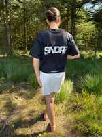 Modelfoto af pige, som bærer SNDRB t-shirt, sort og hvid nederdel - alt fra BySofieSønderby