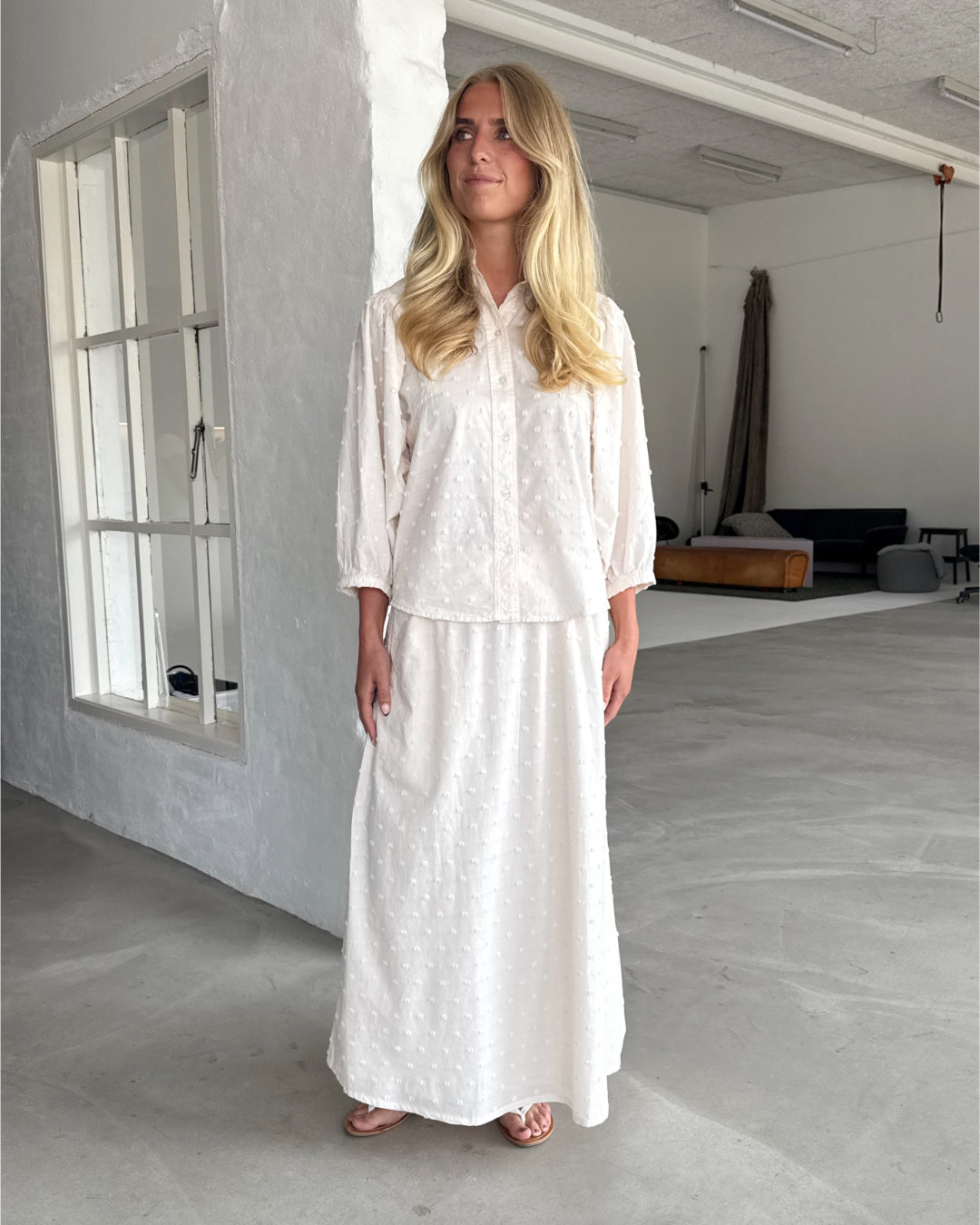 Modelfoto af pige som bærer cremefarvet SUNELA nederdel, samt tilhørende SUNELA skjorte. Alt er fra BySofieSønderby