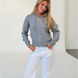 Modelfoto af pige i grå THESS  strik hoodie, samt hvide NANNA jeans. Alt er fra BySofieSønderby.