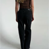 Modelfoto af pige som bærer et par sorte Tokyo jeans, samt iført en brun Thora one shoulder top. Alt fra By Sofie Sønderby