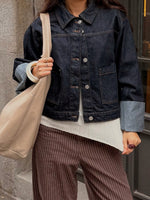 Modelfoto af pige i mørkeblå VEGA denimjakke, samt brune MADDY bukser med lyserødestriber. Fra BySofieSønderby