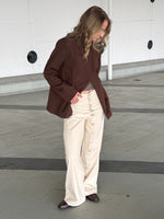 Stemningsbillede af cremefarvet ZOE jeans med knapdetaljer. Set forfra. Fra BySofieSønderby