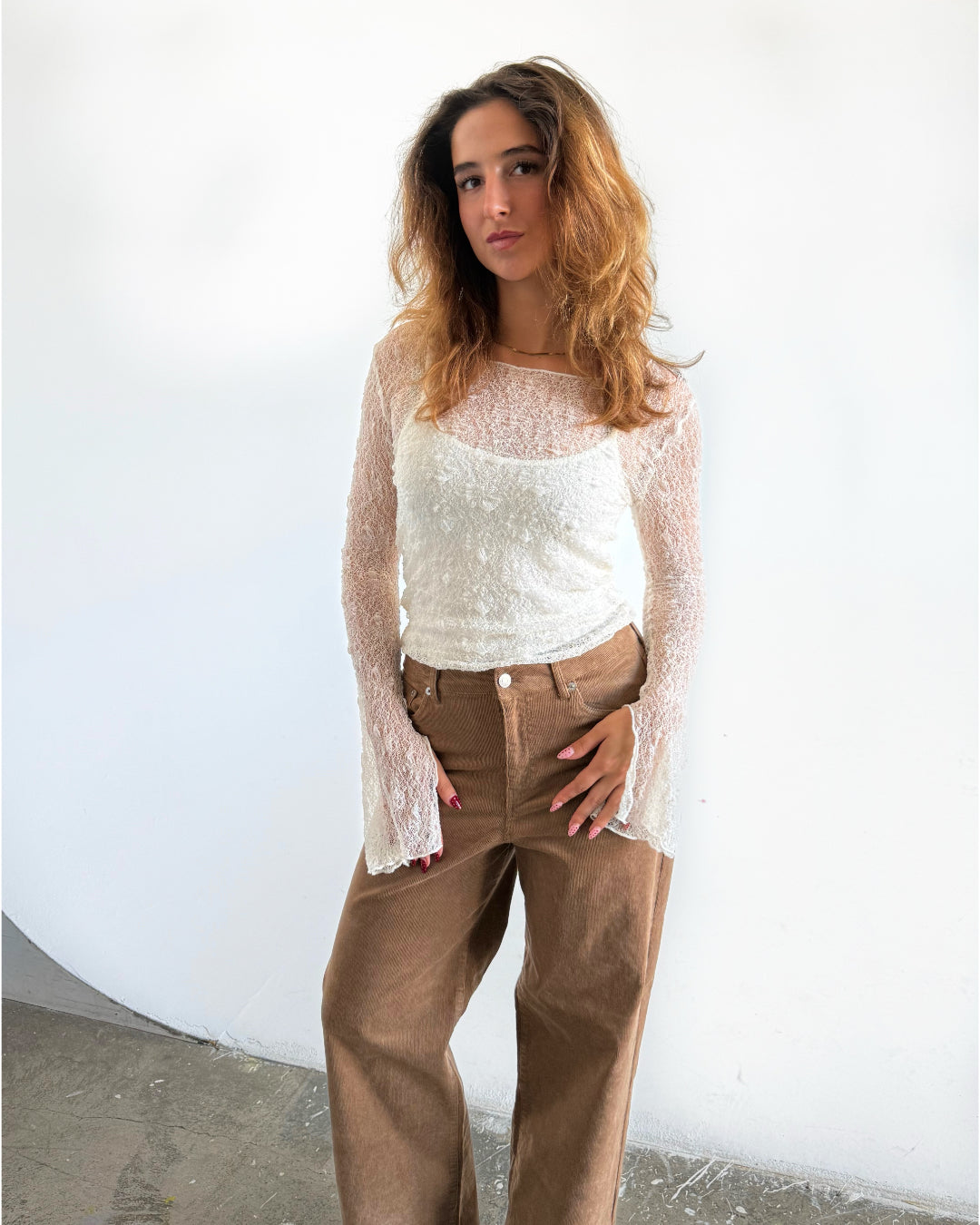 Modelfoto af pige i hvid Zoya blondebluse og brune Gelly bukser. Alt er fra BySofieSønderby